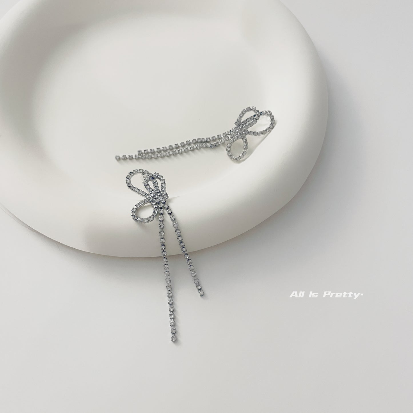 Crystal bow tassel clip earrings